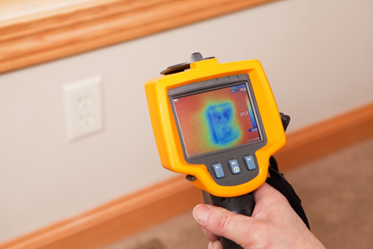 Using a thermal imaging camera to find areas of heat loss in a home.